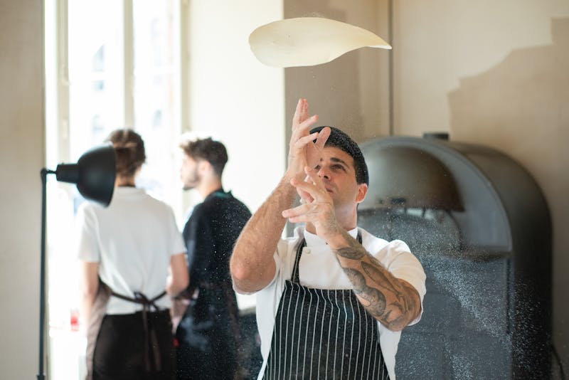 Dewey's Pizza kitchen team preparing fresh pizzas together